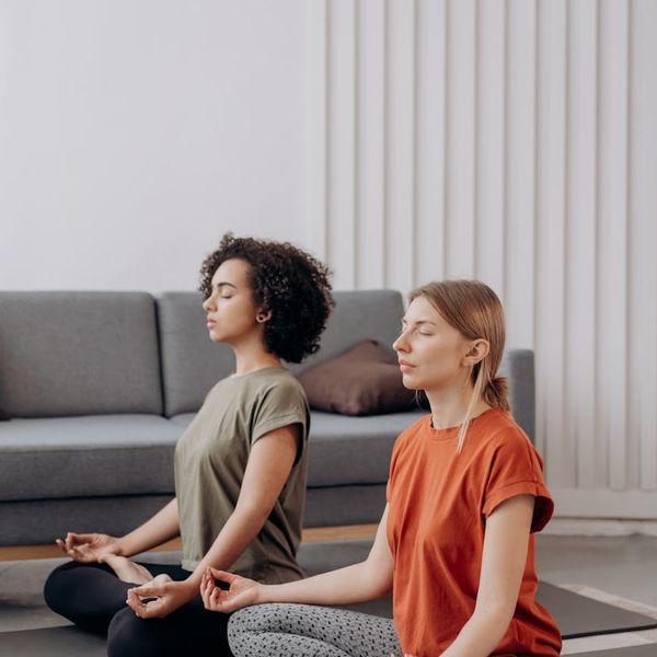 Woman performing a vibrant yoga pose in a sunlit room.